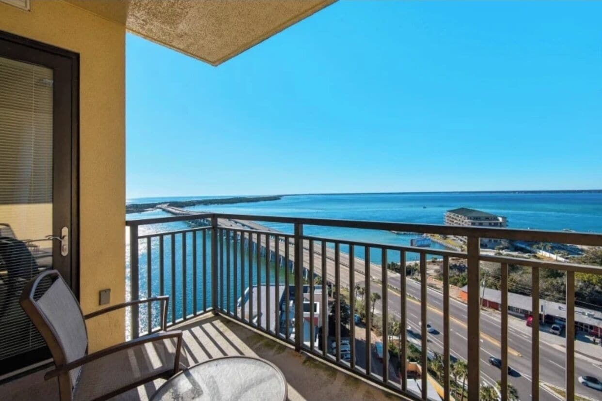 A balcony with a view of the ocean and a road.