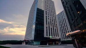 Un moderno edificio de gran altura con un llamativo frente de vidrio y un letrero que dice "WYNDHAM GARDEN".