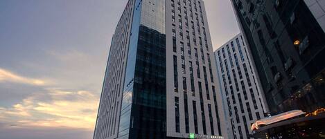 A modern high-rise building with a prominent glass facade and a sign reading "WYNDHAM GARDEN".