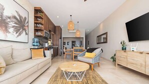 A modern living room with a sofa, a coffee table, and a dining area. - Oceanfront  Condo at Costa Azul Beach ! (San José del Cabo)