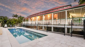 A poolside view of a house with a swimming pool, a covered patio, and a decorative fence. - WESTACOMBE -  boat parking plus amazing pool, pet friendly (AGNES WATER)