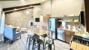 A modern kitchen with a built-in stove, stainless steel appliances, and a stone accent wall.