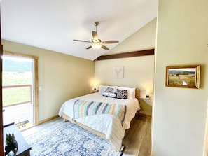 A bedroom with a bed, a ceiling fan, a door to a balcony, and a framed picture on the wall. - 20% SUMMER DISCOUNT New Construction Luxury Condo (Angel Fire)