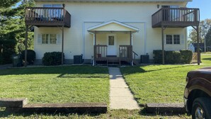 Une maison à deux étages avec un porche à l’avant, un garage et une allée.