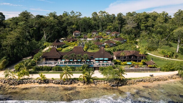 Un resort con varias edificaciones, una zona de piscina y acceso directo a la playa.