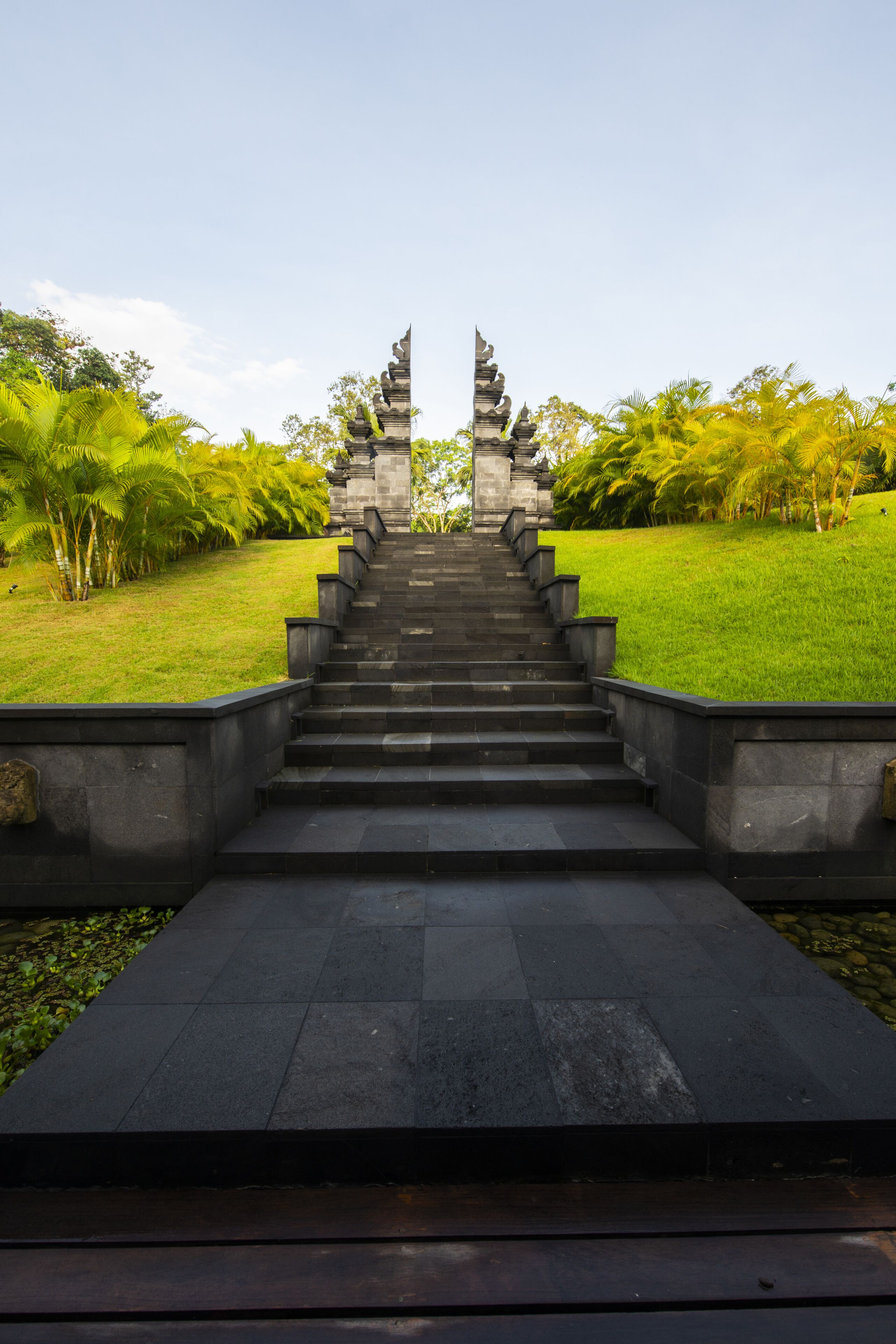 Un escalier menant à un temple, lui-même entouré d’une végétation luxuriante.