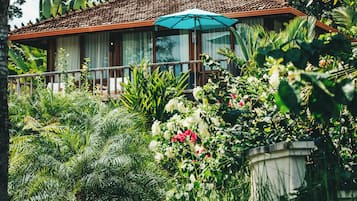 A house with a tiled roof, surrounded by lush greenery and flowering plants.