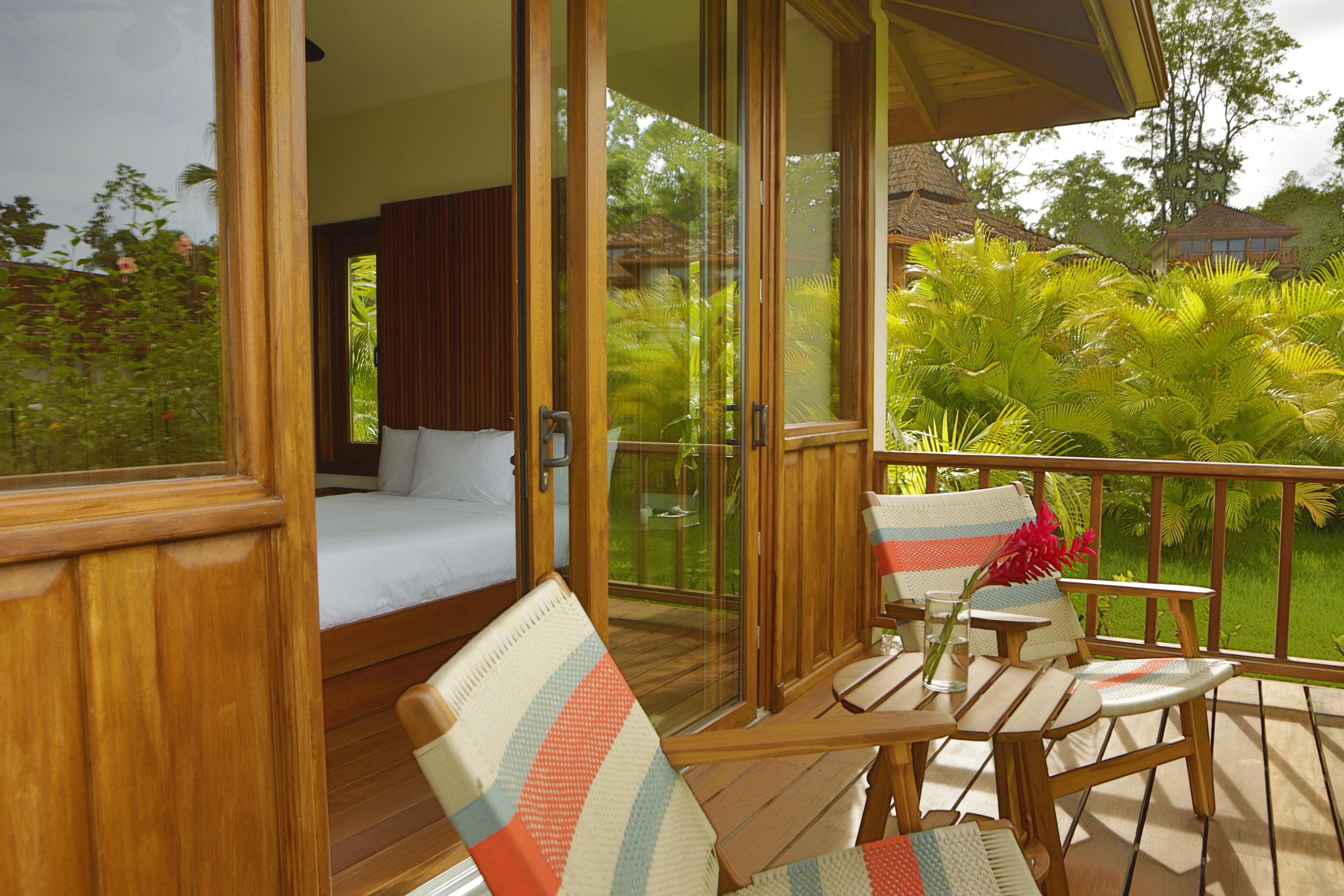A balcony with a bed, a table, and chairs.