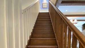 Una escalera de madera con barandillas blancas que lleva a una plataforma.