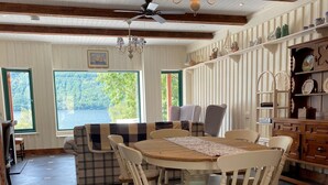 Un comedor con una mesa redonda, sillas y un ventilador de techo.