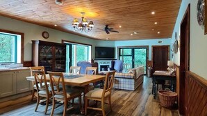 Un coin repas avec une table et des chaises en bois, un canapé et un téléviseur.