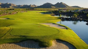 A golf course with a water hazard, sand bunkers, and a flagstick. - 3 bedroom house with Golf, pool, hot tub, gym, biking, and much more (Buckeye)