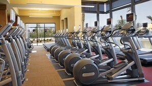 A gym with multiple treadmills and elliptical machines arranged in rows. - 3 bedroom house with Golf, pool, hot tub, gym, biking, and much more (Buckeye)