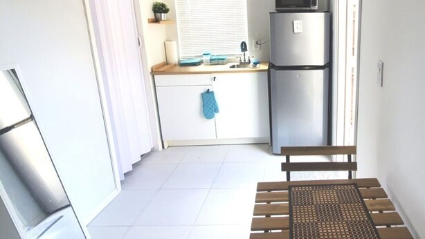Eine kleine Küche mit Kühlschrank, Mikrowelle und einer Arbeitsplatte.
