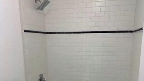 Ein kleines, weißes Badezimmer mit Toilette, Waschbecken und Badewanne.