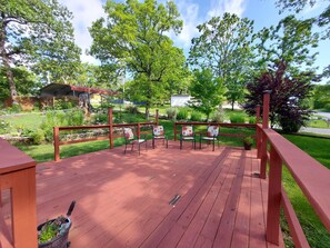 A wooden deck with chairs and a potted plant.