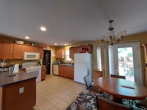 Enjoy cooking in this well-equipped kitchen with a microwave, oven, and refrigerator, and dine at the adjacent table and chairs.