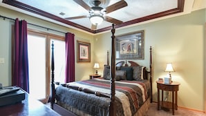 A four-poster bed with a wooden headboard, a ceiling fan, and a large window with curtains. - Welcome Inn- Pools - Great Balcony - Trails to Fishing -SO Close to Sdc!! (Branson West)