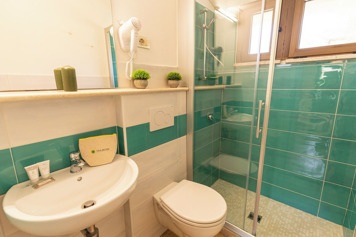 A bathroom with a sink, toilet, and shower area.