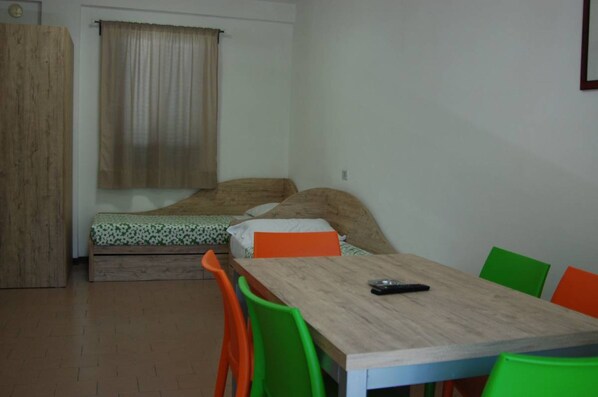 A small room with a bed, a table, and chairs.