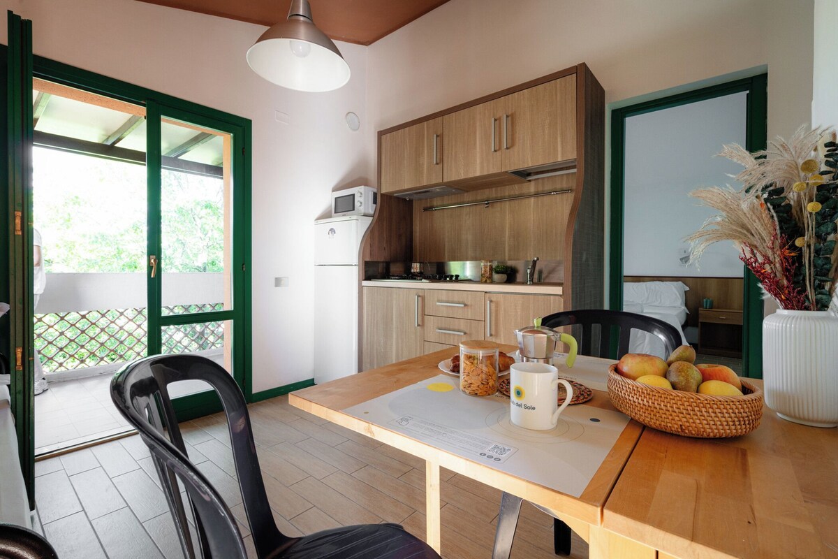 A kitchen with wooden cabinets, a microwave, and a dining table with chairs.