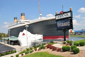 A large ship with a Titanic sign and a large iceberg model in front. - Shelter in Faith - Amazing Golf Views - Blocks From 76 Strip Location (Branson)