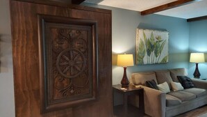A living room with a wooden accent wall, a sofa, two side tables with lamps, and a framed artwork. - Solace Space at Foothills - Close To All Of Branson - Luxury Comfort (Branson)