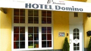 A hotel named HOTEL Domino with a white facade, large windows, and a prominent entrance door. - Hotel Domino (Hanau)