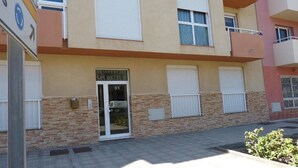A residential building with a stone facade, numbered 31, and a glass door entrance. - Suncanarias Apartamento Marina (San Miguel de Abona)
