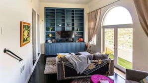 Una sala moderna con un sofá, una mesa de centro y un televisor sobre un mueble azul.