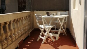A small balcony with a white table and chairs, a metal pot, and a white mug. - Hostmate - Milano - Cantoni - Washington  (Milano)