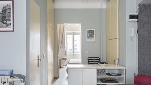A hotel room with a kitchenette, a dining area, a bed, and a view of the street. - Hostmate - Milano - Cantoni - Washington  (Milano)