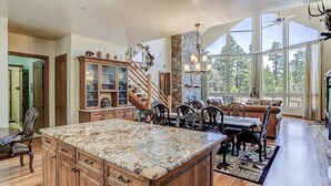 A spacious kitchen with a large island, wooden cabinets, and a dining area with a staircase leading to a loft. - The EXECUTIVE LEVEL retreat for families and outdoor lovers in Happy Jack, AZ! (Happy Jack)