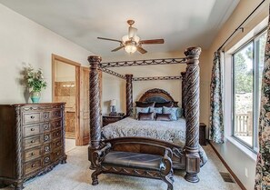 Una cama con dosel, un aparador de madera y un banco.