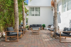 An outdoor seating area with a sofa, chairs, and a table.