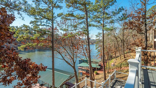 A lakeside view with a wooden deck, a gazebo, and a building with a green roof. - Lakefront Home w/ Dock: 10 Mi to Central Ave! (Hot Springs)