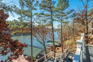 Une vue sur le lac, avec une terrasse en bois, un belvédère et un bâtiment doté d’un toit végétalisé.