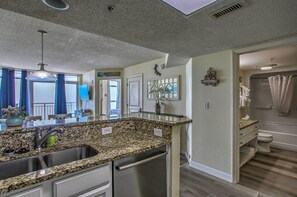 A kitchen with granite countertops, stainless steel appliances, and a built-in dishwasher. - Bay Watch Condo w/ Oceanfront Balcony & Beach View (North Myrtle Beach)