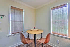 A corner room with two windows, a round table, and two chairs. - 16 Mi to Disney: Cottage w/ Deck in Winter Garden (Winter Garden)