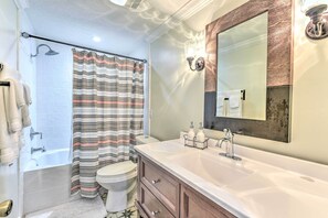 A bathroom with a bathtub, toilet, and a large mirror above the sink. - 16 Mi to Disney: Cottage w/ Deck in Winter Garden (Winter Garden)