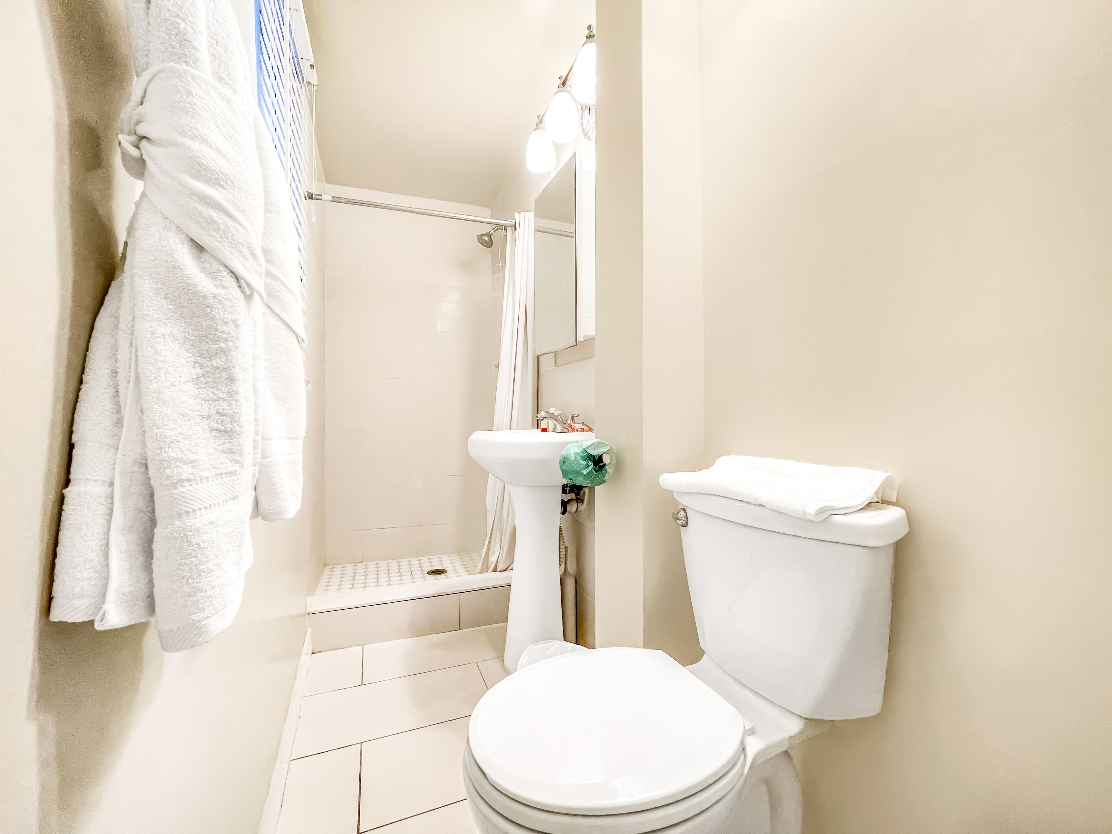 Un baño con inodoro, lavabo y zona de ducha.