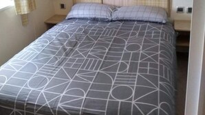 Ein Schlafzimmer mit einem Bett, einem Nachttisch, einer Lampe und einem Kleiderschrank.