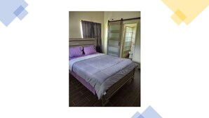 A bedroom with a bed, a nightstand, a wardrobe, and a bathroom visible through a glass door. - Veronica's Villa (St Thomas)