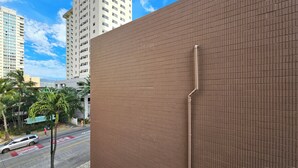 A modern building with a brick facade and a visible utility pipe.