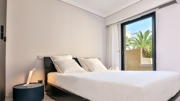 A modern bedroom with a large bed, a bedside table, and a view of the outdoors. - T3 Large Terrace "Capo di Feno" (Ajaccio)