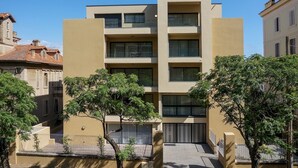 A modern multi-story building with a flat facade, large windows, and a central entrance. - T3 Large Terrace "Capo di Feno" (Ajaccio)