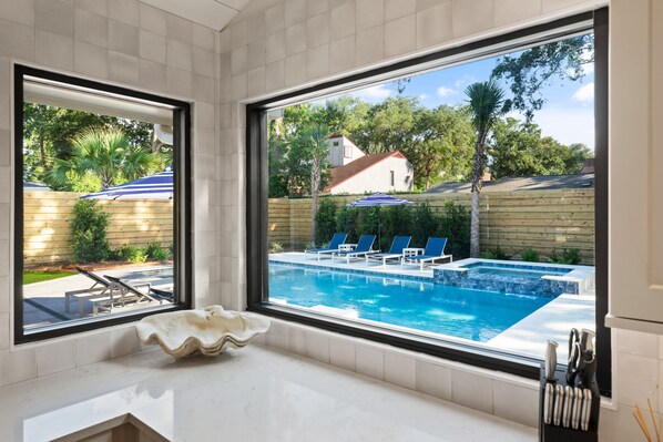 Enjoy a refreshing view of the outdoor pool from the comfort of your bathroom.