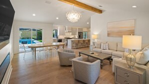 Un amplio salón con una mesa de comedor, sofás y una cocina al fondo.