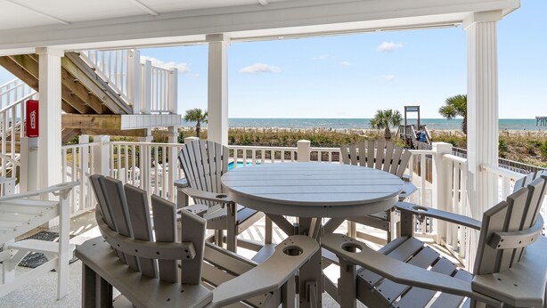 A covered outdoor seating area with a view of the beach. - "Waters Edge 429-D" - Oceanfront Condo w/ Community Pool, 2 Bedrooms / 2 Bathrooms (Holden Beach)