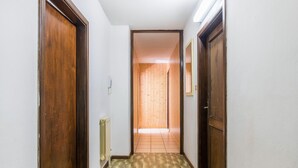 Un pasillo estrecho con puertas de madera y un radiador en la pared.
